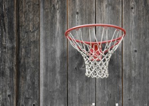 A basketball basket on weathered wooden facade