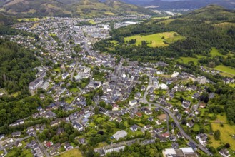 Aerial view, residential area local view, surrounded by hilly forest landscape with forest damage,