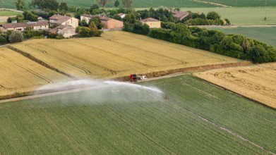 Modern Agricultural Irrigation System Sprays Water Over Green Soybean Fields Under a Bright