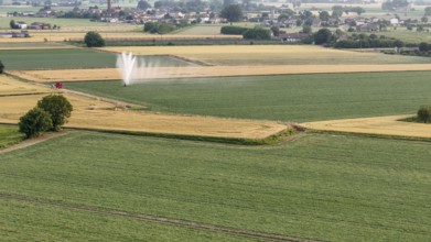 Agricultural irrigation system spraying water on a soybean field during springtime in Italy's