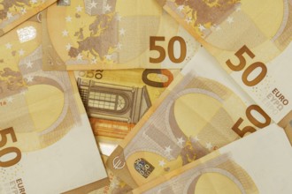 Multiple 50 euro banknotes creating an abstract financial background