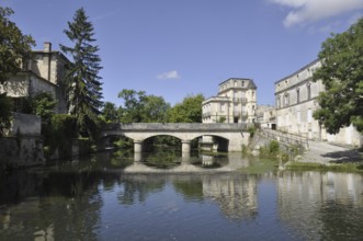 A serene scene with a stone bridge over a reflective river, surrounded by historic buildings and