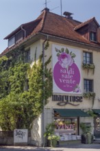 Overgrown façade with floral decorations and advertising poster, Dornbirn, Vorarlberg, Austria