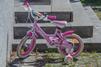 Pink-coloured Unicorn children's bike with training wheels, Dornbirn, Vorarlberg, Austria