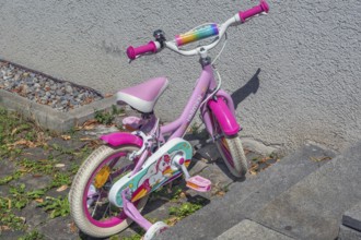 Pink-coloured Unicorn children's bike with training wheels, Dornbirn, Vorarlberg, Austria