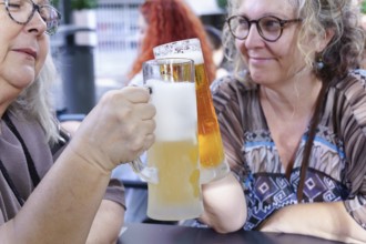 Women enjoying refreshing beer at a pub, celebrating friendship
