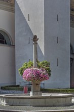 St Martin's Fountain with floral decorations at the parish church of St Martin, Dornbirn,