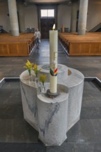The Roman Catholic parish church of St Martin, interior with baptismal font, candle and floral