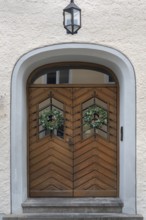 Façade with wooden gate, lantern and ivy wreaths, Kempten, Allgäu, Bavaria, Germany