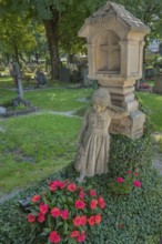 Gravesite with mourning girl figure, ivy and floral decoration, catholic cemetery, Kempten, Allgäu,
