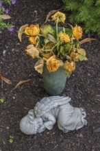 Gravesite with sleeping putti and wilting yellow roses, catholic cemetery, Kempten, Allgäu,