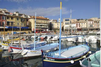 Cassis, the port, A vibrant harbor scene with colorful boats floating in calm water, lined by