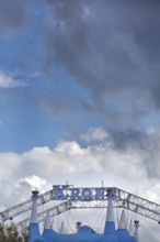 Circus tent, circus tent with luminous lettering in front of a blue sky with white and grey clouds,