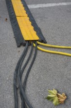 Power cable with cable bridge on asphalt, Circus-Krone, Kempten, Allgäu, Bavaria, Germany