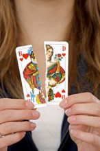 Woman holding a torn playing card in her hand