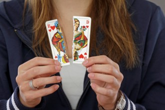 Woman holding a torn playing card in her hand