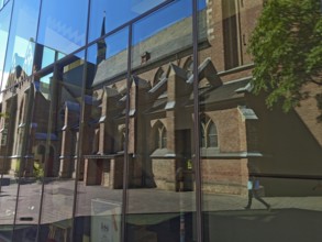 Old town with catholic reflection of St Margaret's Church in glass front, brick building,