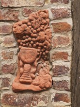 Clay work in house wall, pottery, handicraft, art, grapes, wine glass, red clinker, wooden beams,