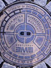 Cover of a water meter pit, water meter pit, city centre, street, round cast iron shape, standard,