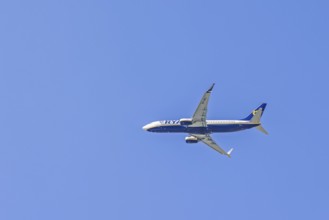 Ryanair passenger plane flying on the blue sky