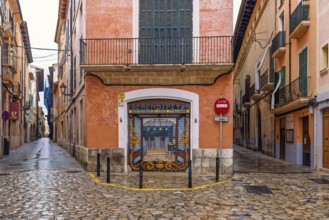 Empty street in a residential area with a painting on a shutter at a cafe on a street corner, Palma