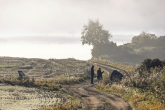Pair on a winding gravel road in the countryside a misty autumn morning