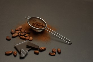 Kitchen sieve with cocoa powder and chocolate, cocoa and cocoa beans
