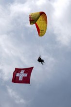 Paragliding tandem flight with Swiss flag, Interlaken, Switzerland