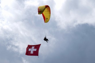 Paragliding tandem flight with Swiss flag, Interlaken, Switzerland