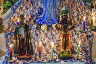 Umbanda altar with its deities and objects of worship lit by candles at night, Belo Horizonte,