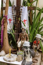Divinities and objects from Umbanda and Cotolicism mixed on an altar among the plants, Belo