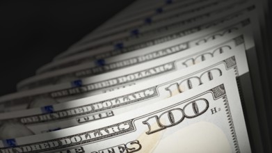 Spot lit abstract close-up angle of U.S. 100 dollar bills isolated on a black background