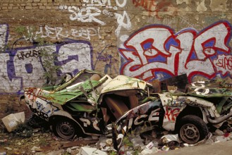 A crashed car in front of the Berlin Wall, in the 1990s, Berlin, Germany