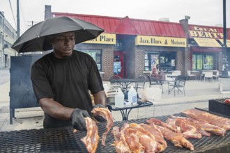 Detroit, Michigan - Wearing an umbrella, a worker places pork on the grill at Bert's Market Place