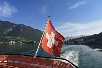 Swiss flag in the stern of the motor ship Brunnen in motion, Lake Lucerne, Brunnen, Canton, Schwyz,