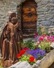 Carved wooden figure of the Virgin Mary with the infant Jesus, wooden trough decorated with
