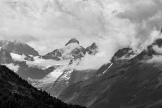 Four-thousand metre mountains and glaciers in clouds, black and white photograph, above Zinal, Val