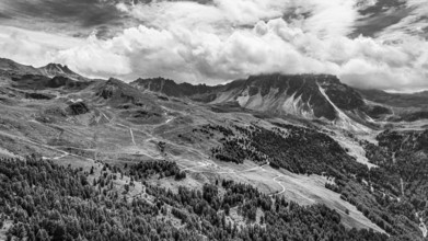 The summit of the Weisshorn enveloped in clouds, alpine pastures above Saint Luc, drone shot, black