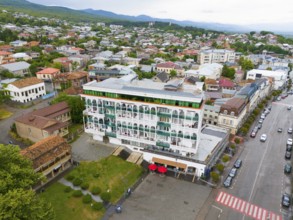 Modern buildings and streets with parked cars in a neighbourhood under a cloudy sky, aerial view,