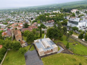 Historic buildings surrounded by greenery in an urban landscape under a cloudy sky, aerial view,
