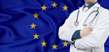 European Union healthcare concept. Male doctor on European Union flag. Doctor with crossed arms on