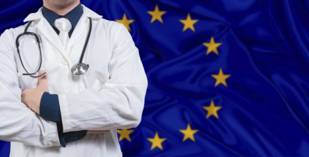 Male doctor with stethoscope on European Union flag. Doctor holding stethoscope on European Union