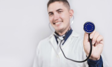 Doctor showing stethoscope with European Union flag. European Union national healthcare concept