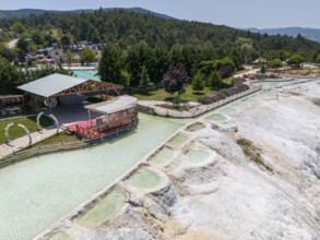 Panoramic view of limestone terraces next to a green park with a red platform, aerial view, Akkaya