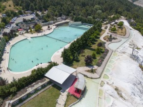 Large swimming pool with park in green landscape, people enjoying the facility, aerial view, Akkaya