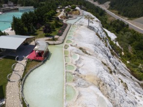 Limestone terraces with flowing water in the middle of a green landscape, aerial view, Akkaya