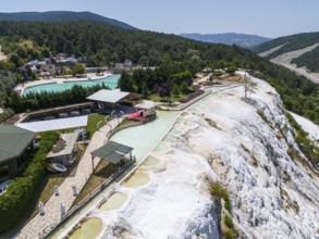 Thermal springs and buildings in a green landscape with limestone formations, aerial view, Akkaya