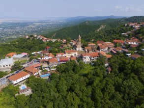 Sweeping view over a hilly region with town and traditional buildings, aerial view, Sighnaghi,