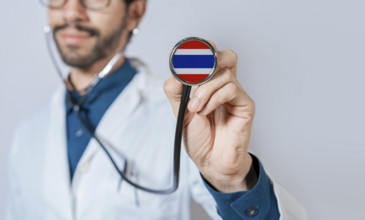 Doctor holding stethoscope with Thailand flag. Thailand health and care concept, Thailand flag on