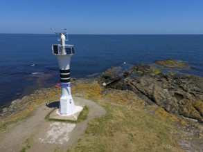 Close-up of a lighthouse on a rocky coast with the wide sea and blue sky, aerial view, Yason Burnu